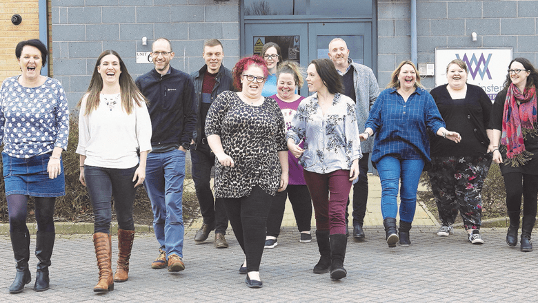 The Transform your Training team are walking together outside, smiling and laughing. They appear to be enjoying a light-hearted moment as they move toward the camera in a casual, relaxed manner.